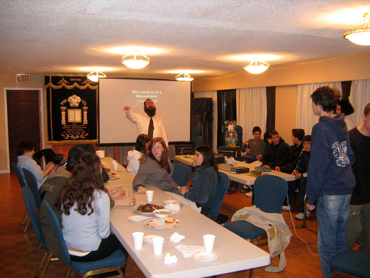 Des jeunes du "Sunday School" (Talmud Torah) à Richmond BC Canada durant la fête Hanouccah, en train de jouer au ''qui veut être un Mitzvanaire?'' dirigé par Malky Bitton et le Chlia'h de la ville, Yehiel Baitelman.