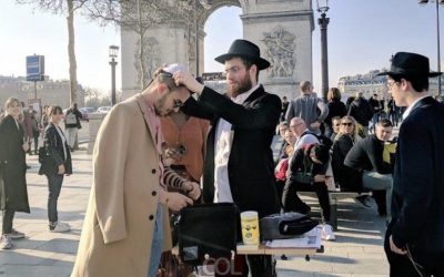 Réponse à l’antisémitisme en France :  Devant l’Arc de Triomphe et le regard étonné des passants, des Loubavitch mettent les Tefilines au touristes juifs…