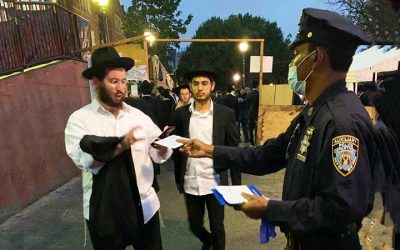Des policiers distribuent des masques aux passants dans le quartier de Crown Heights