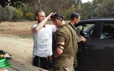 Photo du jour : David Elyahou Kay hy’d, assassiné à Jérusalem, met les Tefilines à des soldats le jour de Pourim